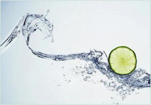 Wallario Vliestapete Limettenscheibe in spritzigem Wasser, Seidenmatte Oberfläche, hochwertiger Digitaldruck, in verschiedenen Größen erhältlich